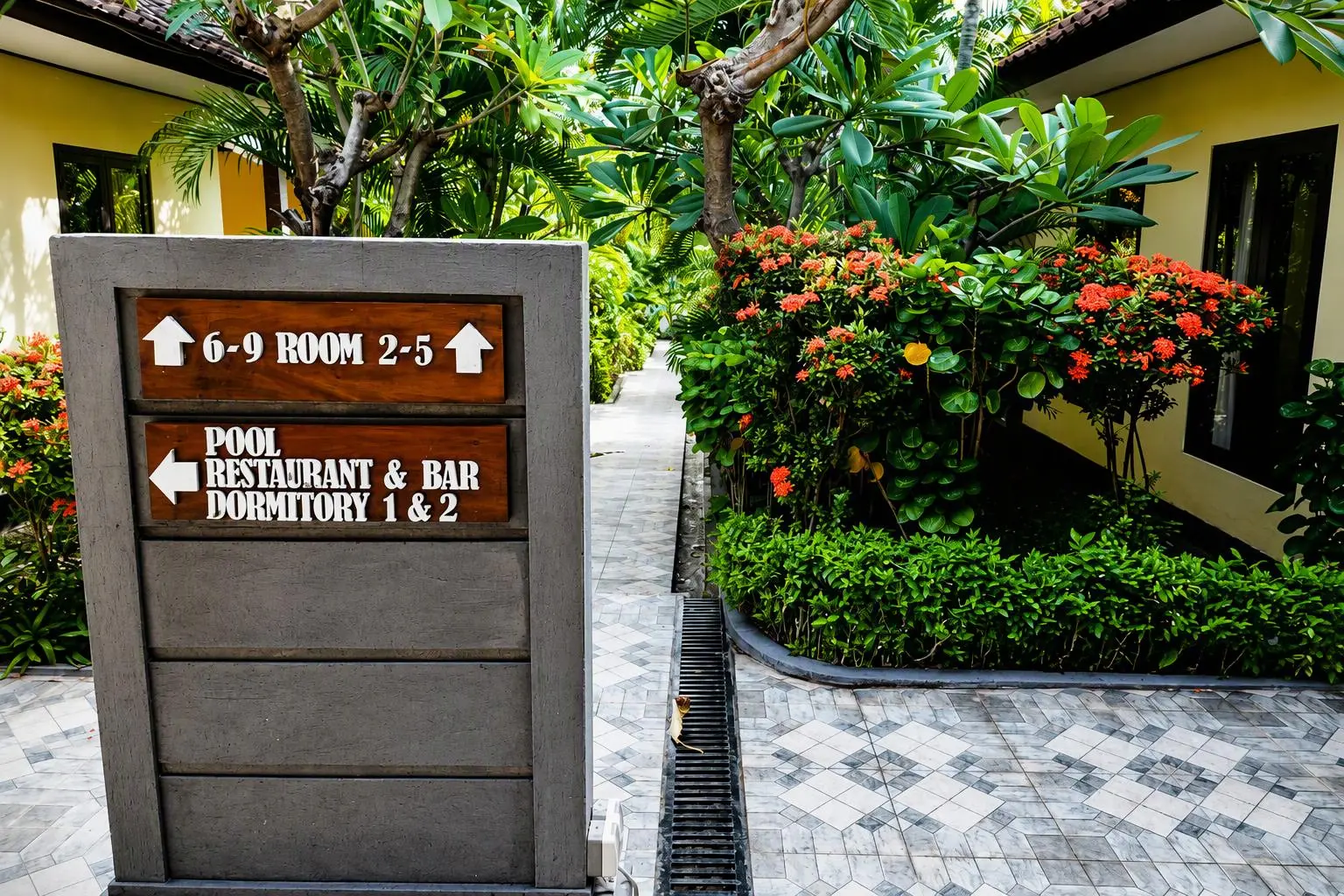 Garden sign pointing to the rooms, restaurant and dormitory